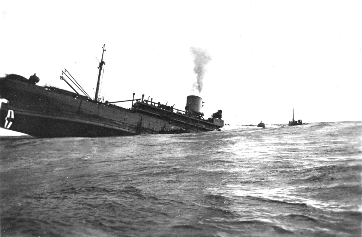 WWII merchant ship with it's bow under the ocean and it's screw high in the air. It is sinking, likely having been struck by a U-Boat torpedo